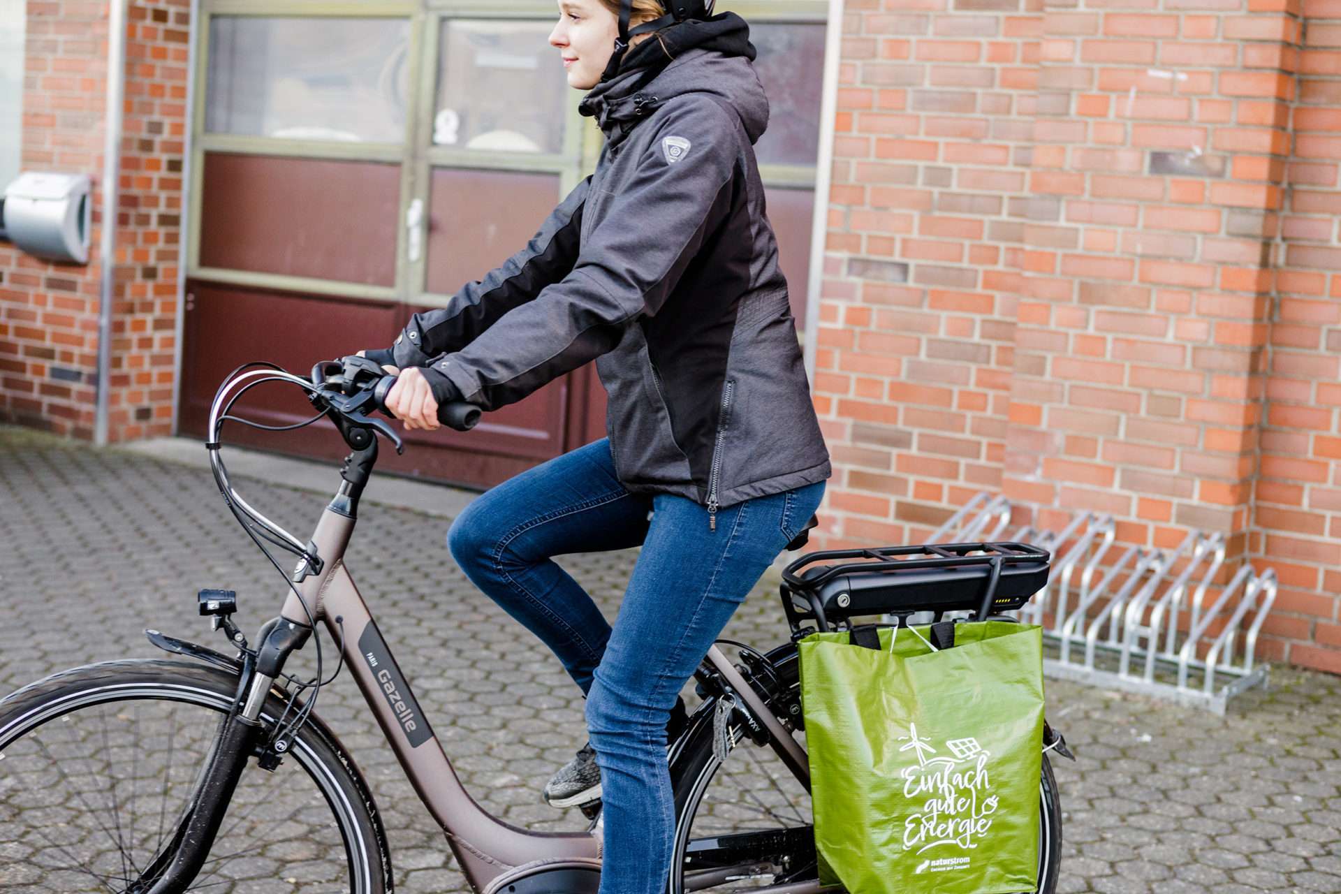 Bringsl nutzt Ökostrom Bild von Naturstrom - Lea auf Fahrrad mit Tasche